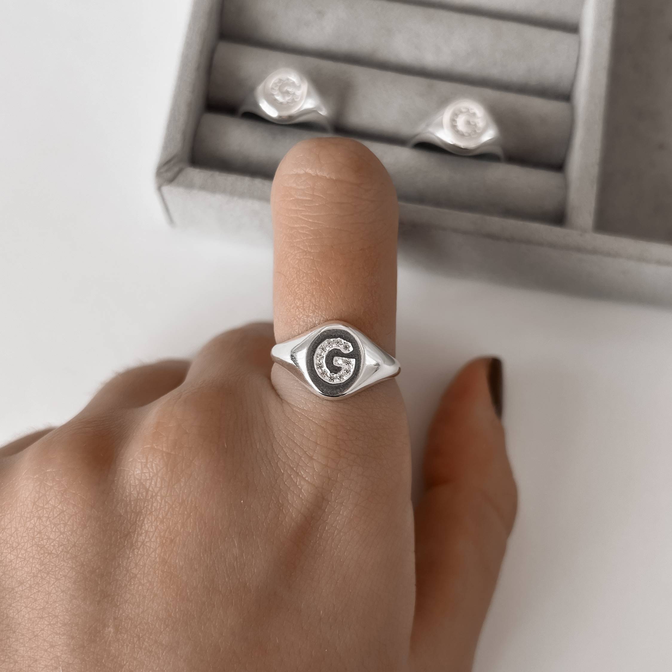 Anel oval letra G cravejada regulável G