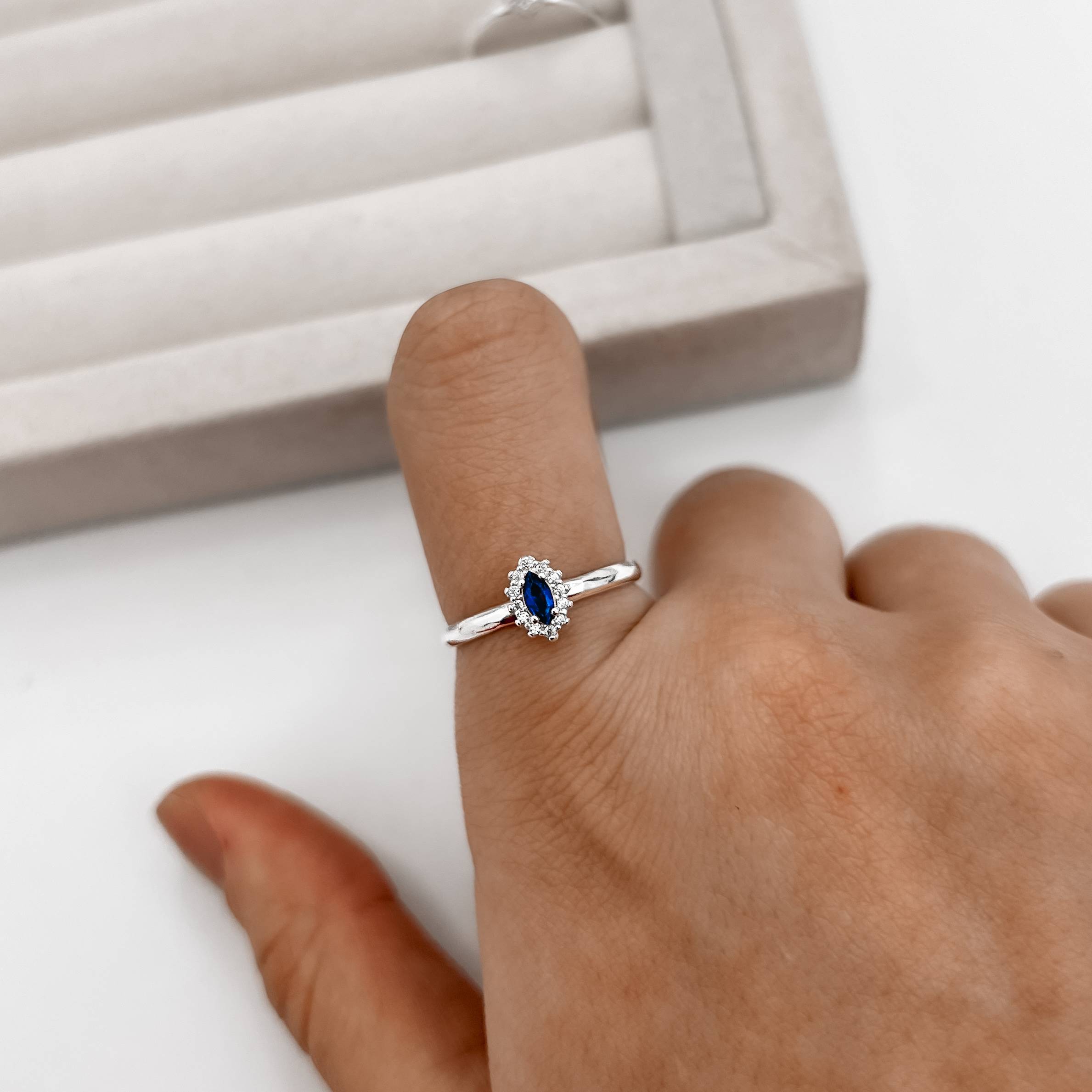 Anel solitário zircônia navete azul com cravejado