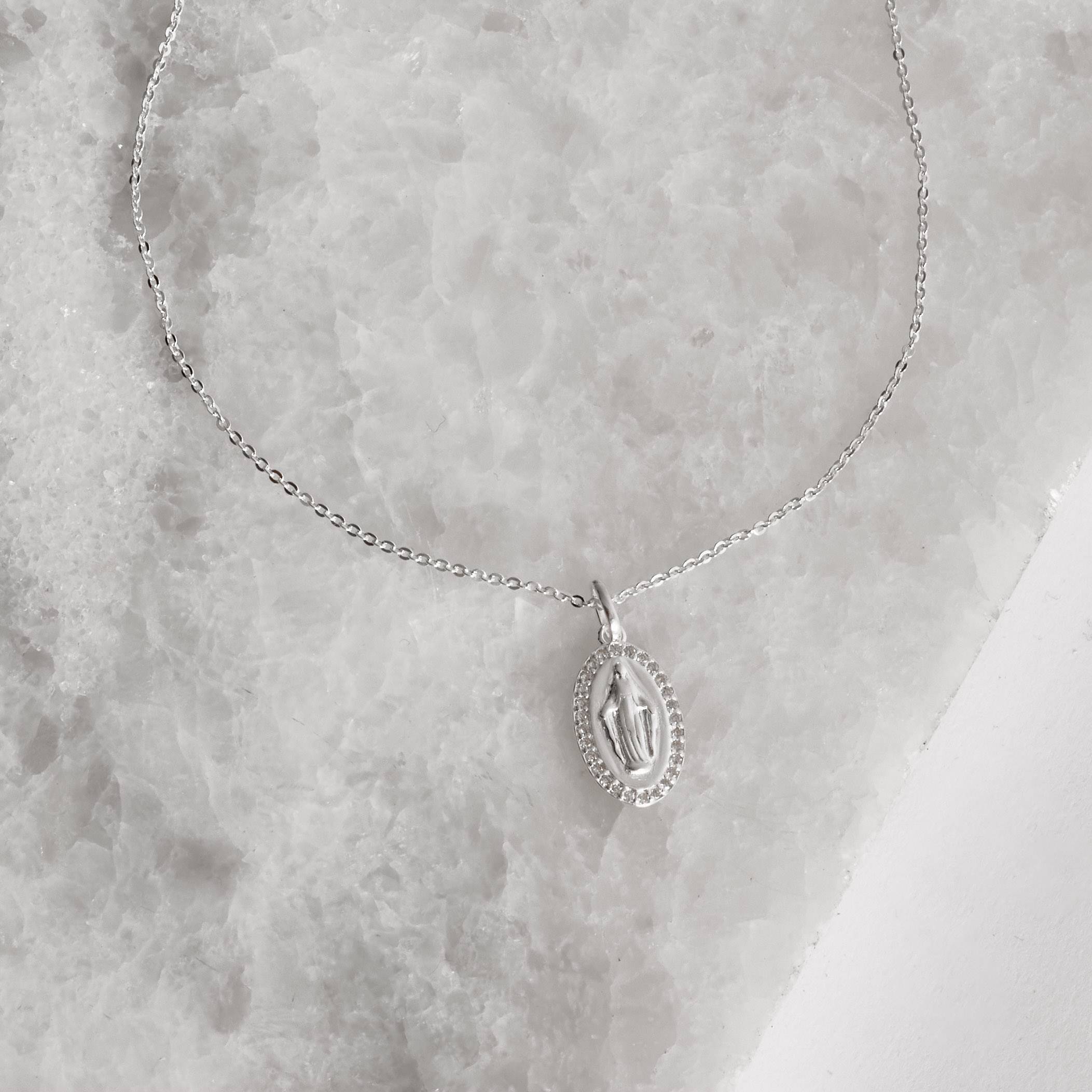 Imagem Secundária Colar pingente medalha Nsa. Sra. das Graças borda cravejada 16mm corrente cadeadinho 45cm