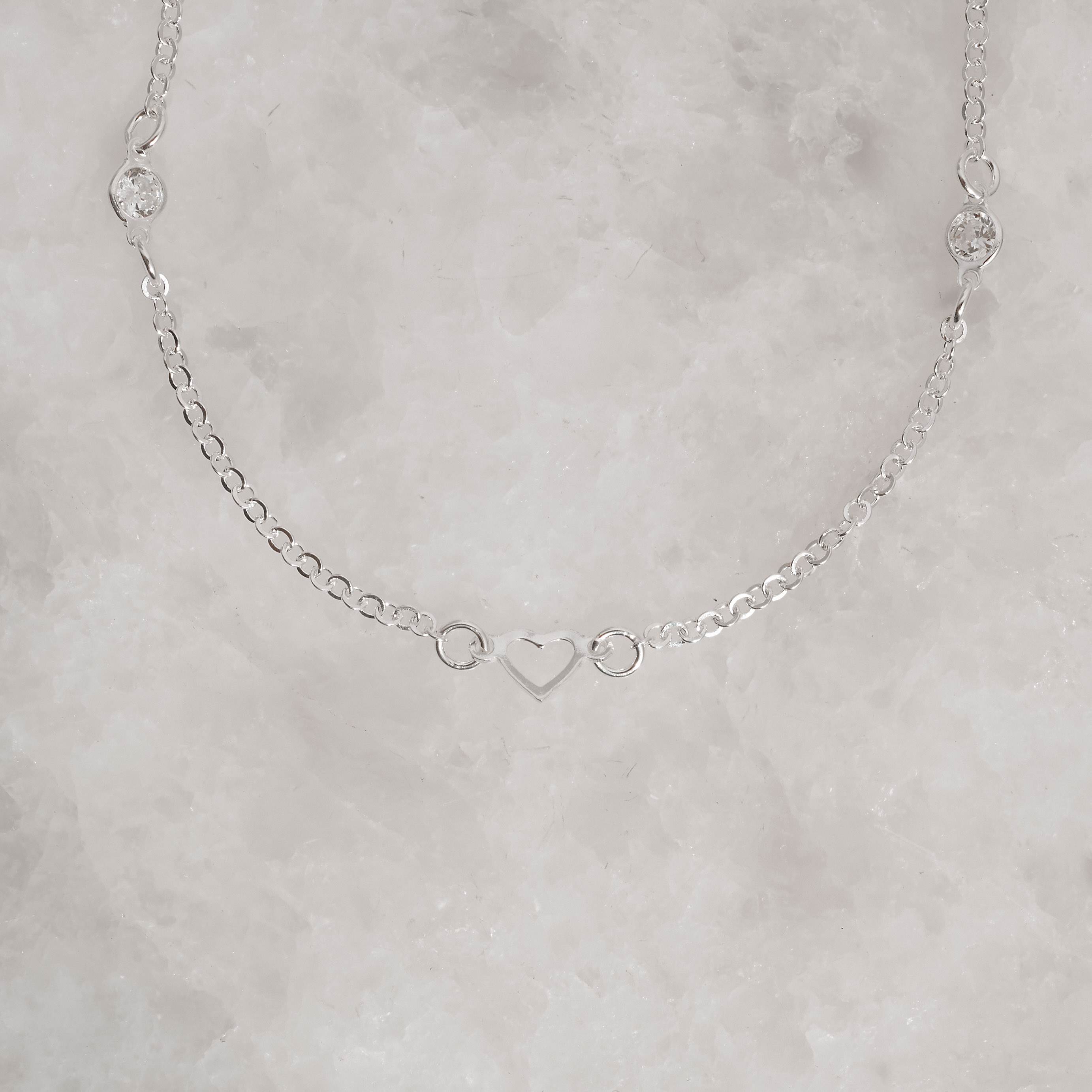 Imagem Secundária Pulseira entremeios zircônias 4mm e coração vazado 19cm